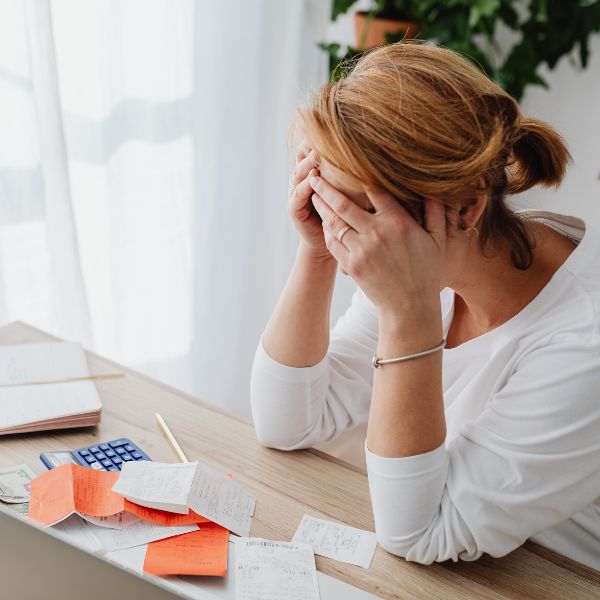 Woman looking frustrated at messy desk